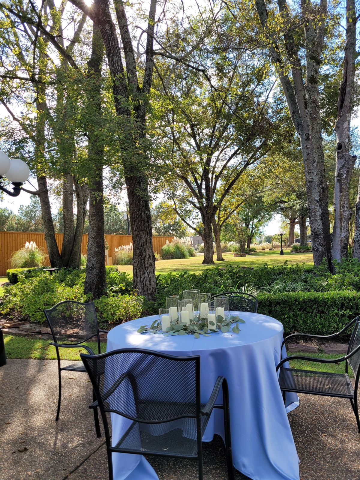 Patio table set with candles under the trees